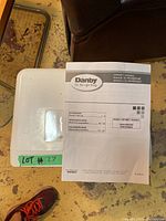 Top-down view of dehumidifier showing owner’s manual on top of unit