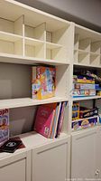 Photo of shelving unit showing various board games including Cranium, The Game of Life, Connect Four