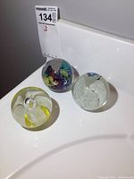 All three glass paperweights showing shapes and internal designs.