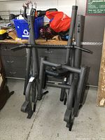 Disassembled Weider Power Tower frame from front view showing padded seat and arm rests, gray metal tubing.