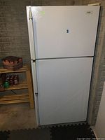 Front view of white Inglis 2 door refrigerator with freezer on top, showing door handles and overall shape.