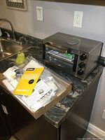 Stainless steel Hamilton Beach toaster oven with cheese making kit on countertop.