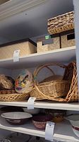 Side shelf view showing a group of wicker baskets including the floral lid basket and multiple other baskets with handles in natural wicker colors.