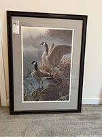 Full view of the framed and matted art piece showing two Canada geese in a wetland setting, signed by Jerry Gadamus. The frame is black with a gray mat.