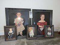 Five framed child portrait art prints by N. Schneeman displayed on floor