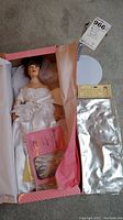 Porcelain bridal doll in original box with booklet, stand, doll covers. Feet still wrapped.