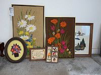 Wide shot of six embroidery framed artworks including floral and nature themes.