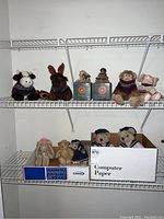 Photo of plush animals and figurines on wire shelves: cow, moose, monkey, pig, teddy bears, and Boyds Bears and Friends figurines.