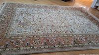 Rug laid flat on wood floor showing full pattern and border.