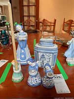 Overview of four blue and white L. Hjorth Denmark angel figurines and Asian-style jar on wooden table indoors