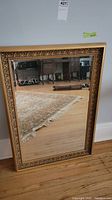 Full view of rectangular mirror leaning against wall