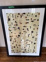 Full view of abstract print in black frame with white mat, showing overall artwork and state of frame.
