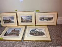 Five framed prints leaning against wall on carpet