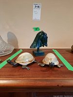 Metal horse head figurine with two stone turtle figurines placed on a wooden surface with green tape measurements, showing approximate size and overall look of the set.