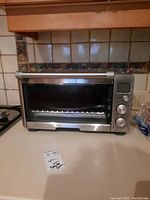 Full view of Breville toaster oven on countertop, front with door and handle visible.