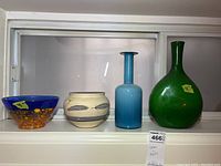 Four vessels displayed side by side on windowsill