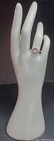 Full hand mannequin view showing the Avon silver pear shape amethyst ring on finger.