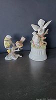 Photo of the ceramic music box featuring white birds on a branch and covered base, about 8 inches tall.