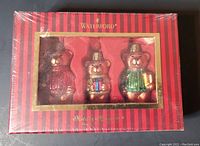 Boxed set of three Waterford glass bear ornaments, vibrant red and gold striped box with clear display showing bears.