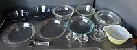 Full view of all glass items including bowls, pie plates, a glass with handle, and a metal handled glass cutter