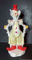 Front-facing photo of the vintage ceramic clown figurine, showing red top hat, ruffled collar, polka dot accents, and red shoes.