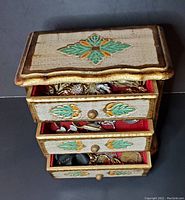 Top-down view showing three partially opened drawers filled with various vintage jewelry.