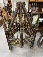 Front view of a 55 inch tall triangular Gothic wooden architectural piece with ornate cut-outs and gold paint accents.