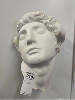 Front view of the plaster neo-classic face sculpture showing facial features and hair details.