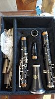 Vintage Vito clarinet disassembled parts laid in the case compartments showing bell, upper and lower joints, barrel, and mouthpiece.