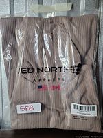 Beige ribbed apparel sealed in original packaging with JED NORTH branding visible.