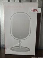 Front view of the packaging box showing the product image of the LED makeup mirror and model number sticker '33B'.
