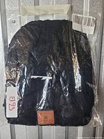 Black knitted music-style hat packaged with labels visible