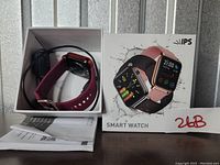 IPS Smart Watch in box with purple strap, charging cable, user manual visible