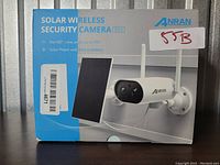 Front view of the Anran solar wireless security camera box showing the camera and solar panel with pan 180° feature noted.