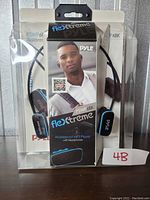 Four packaged Pyle Flexxtreme PSWP66BK waterproof MP3 players with headphones in clear plastic boxes showing the product and branding.