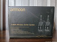 Front view of the Ammoon 2.4GHz Wireless Guitar System box showing features including low noise and latency, USB charging port, approx. 30-meter range, rechargeable lithium battery, and 280° rotatable 1/4" plug.