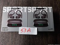 Two boxed Korski Sport Wireless Earbuds, model i21, showing front packaging with earbuds and charging case image.