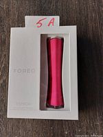 Front view of FOREO Espada device in white packaging showing pink handheld device with '5A' tag