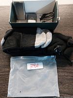 Photo showing the heated socks laid out with battery pack, charger, and cables in a box.