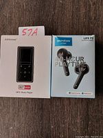 Front view of both product boxes showing Soundcore Life P2 earbuds and AiMoonsa MP3 player