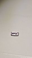 Top-down view of a rectangular light pink off-white kunzite gemstone showing its faceted cut and size.