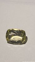 Top-down photo showing the lemon yellow cushion cut citrine gemstone with visible facets and transparent clarity.