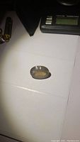 The large oval concave cut whiskey citrine gemstone placed on a white surface showing its size and shape.