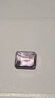Top view of the medium pink purple emerald cut amethyst gemstone showing cut and color.