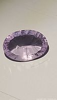 Top-down view of the amethyst showing the oval shape and faceting reflecting light.