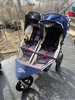 Front left view showing two side-by-side seats, canopies, front wheel and fabric wear