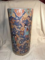 Full front view of the chinsoiserie ceramic umbrella stand showing detailed floral and figure design against a predominantly blue background.