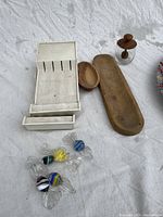 Photo showing the olive wood dishes, glass honey dispenser with wooden dipper, white plastic Cutco trays, and decorative Murano-style glass candy pieces.