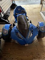 Front view of the blue Power Wheels Boomerang children's ride-on vehicle showing black windshield with logo, wide front tires, and molded plastic body.
