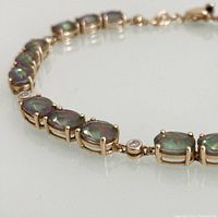 Close-up of iridescent oval mystic topaz and bezel-set diamond segment